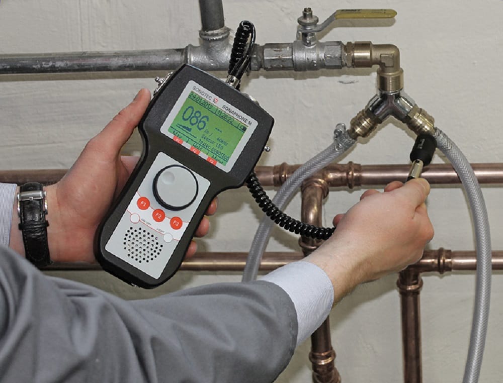 Plumber testing pipes with electronic leak detection equipment in Upland