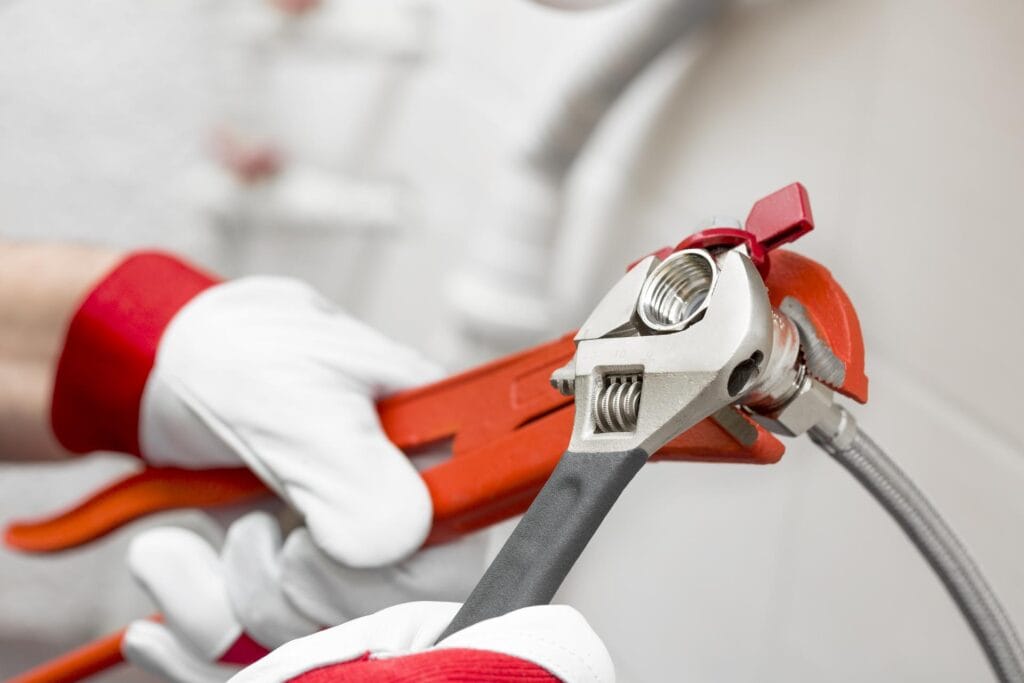 Plumber holding pipe wrenches for an emergency repair in Upland