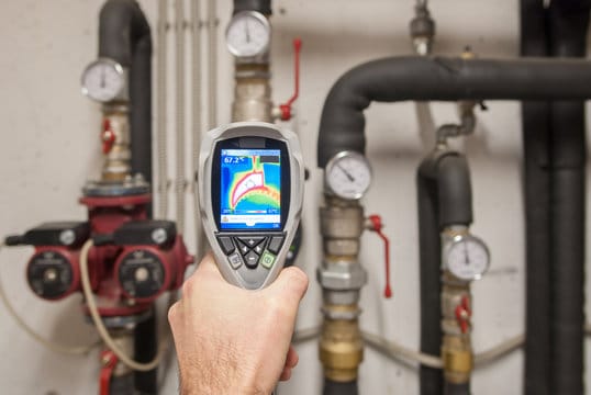 Plumber using a thermal imaging camera to inspect pipes in Upland