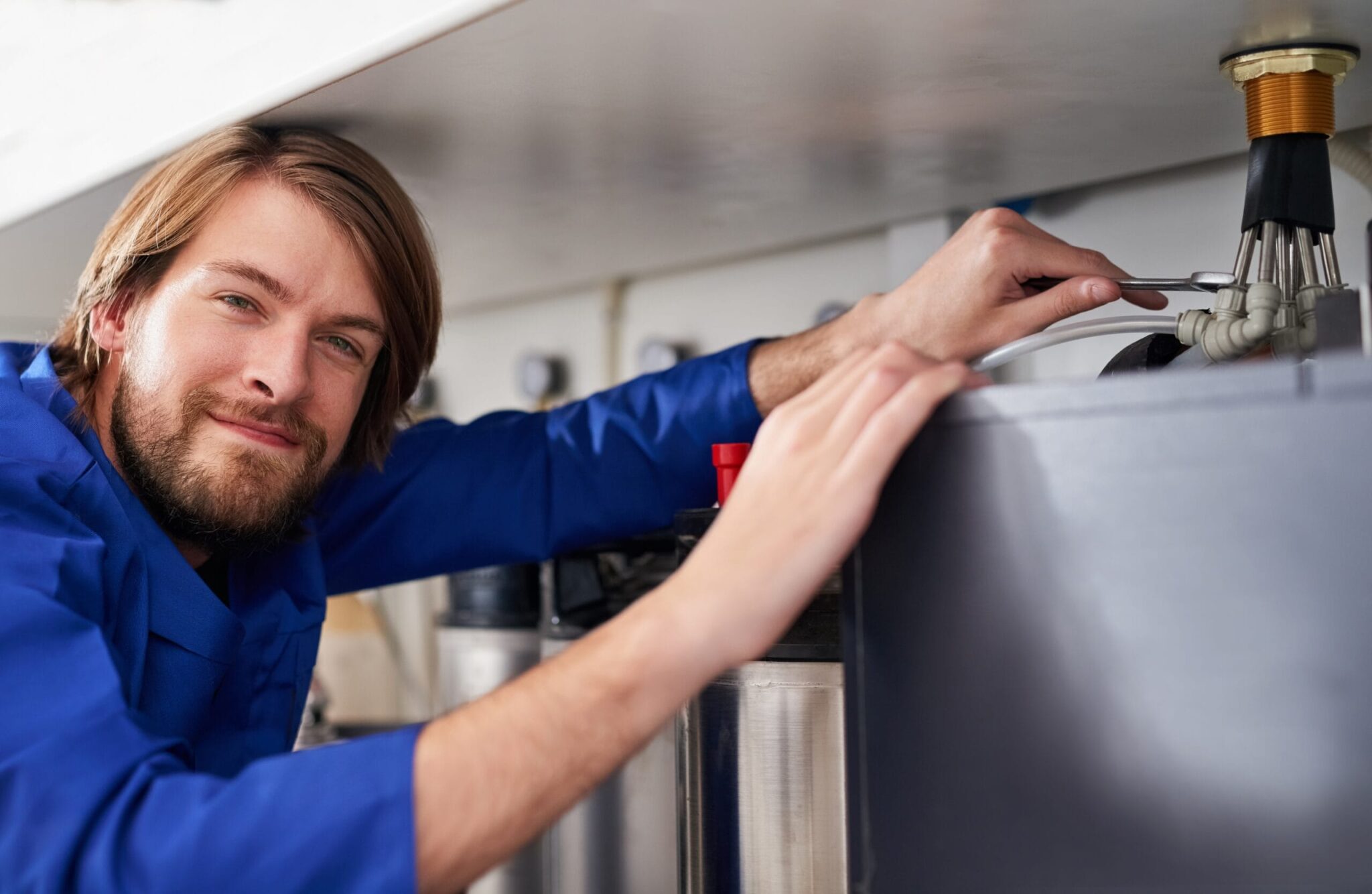 Technician servicing a residential water heater tank in Upland